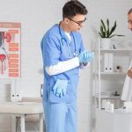 Lekarz rozmawia z pacjentem, który trzyma się za brzuch
