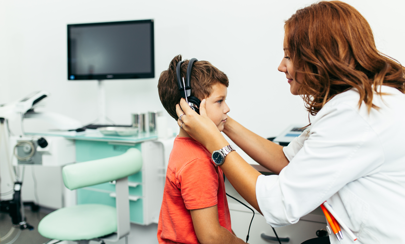 Laryngolog wykonuje test diagnostyczny u dziecka z wysiękowym zapaleniem ucha