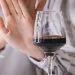 Kobieta odmawia wypicia kieliszka alkoholu.