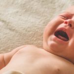 płaczące niemowlę z katarem przy ząbkowaniu