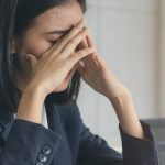 Młoda kobieta cierpi na zaburzenia widzenia, przeciera oczy.