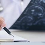 neurolog analizuje wyniki badań podczas konsultacji z pacjentem