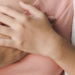 Zatorowość płucna - kobieta trzyma się za klatkę piersiową, odczuwa ból, dyskomfort.
