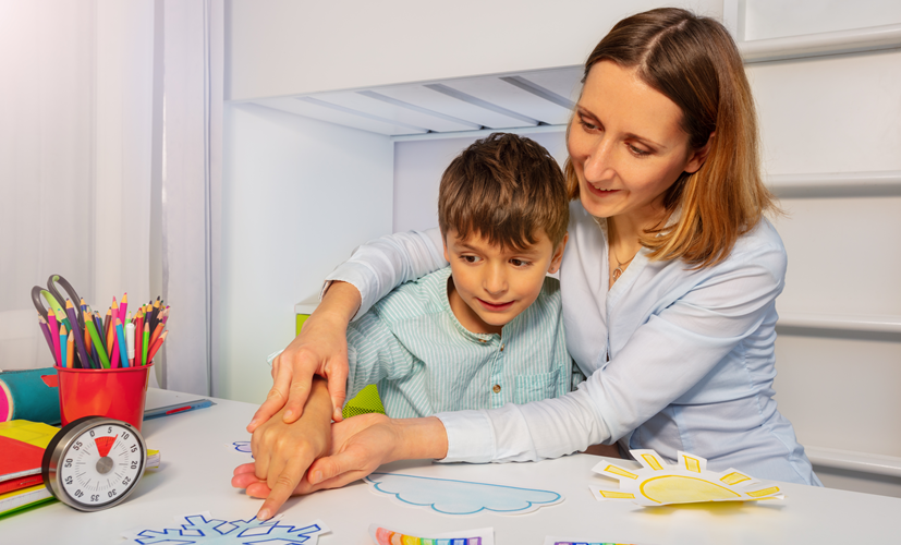 Terapeuta ćwiczy komunikację z chłopcem w spektrum autyzmu