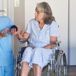 Starsza pacjentka siedzi na wózku inwalidzkim i odbywa rehabilitację neurologiczną po udarze