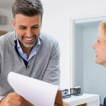 Pacjent rozmawia z recepcjonistką podczas zmiany przychodni POZ
