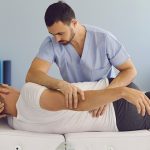 Fizjoterapeuta wykonuje terapie manualną na pacjencie