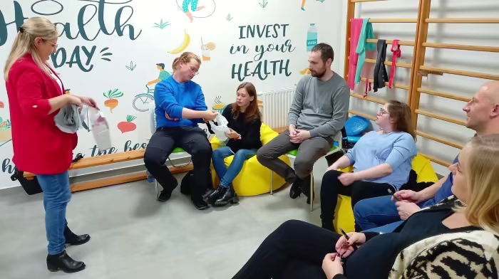 Położna podczas szkoły rodzenia, pokazuje działanie sprzętu niezbędnego dla nowych rodziców rodzenia