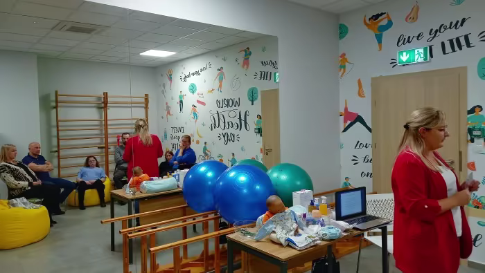 Położna przekazująca przyszłym rodzicom informacje podczas szkoły rodzenia