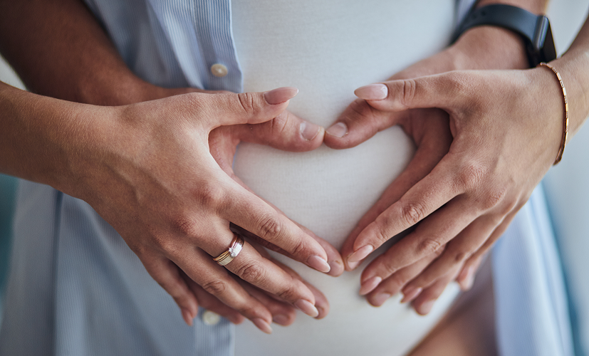 9. tydzień ciąży - mężczyzna okazuje wsparcie trzymając dłonie na brzuchu ciężarnej kobiety