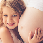 dziecko przytula brzuch mamy w 35. tygodniu ciąży