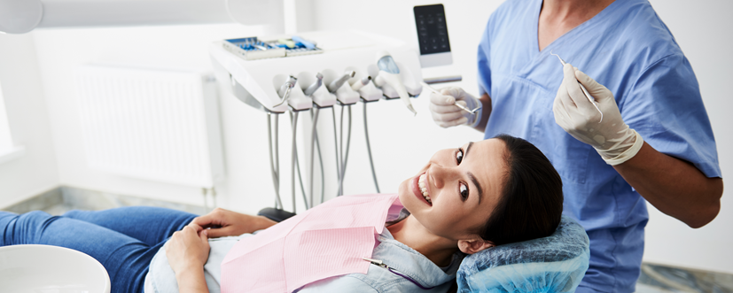 Kobieta lecząca odsłonięte szyjki zębowe u dentysty