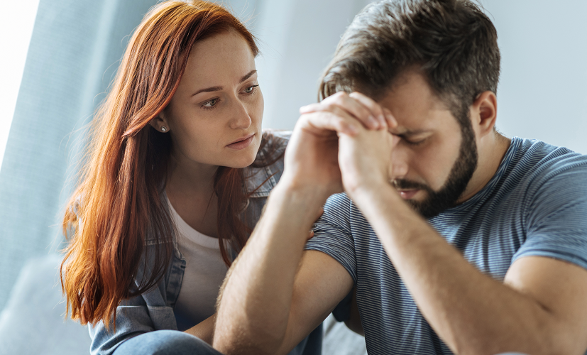 Kobieta pociesza partnera cierpiącego na anhedonię. Anhedonia w związku może znacząco utrudnić relację