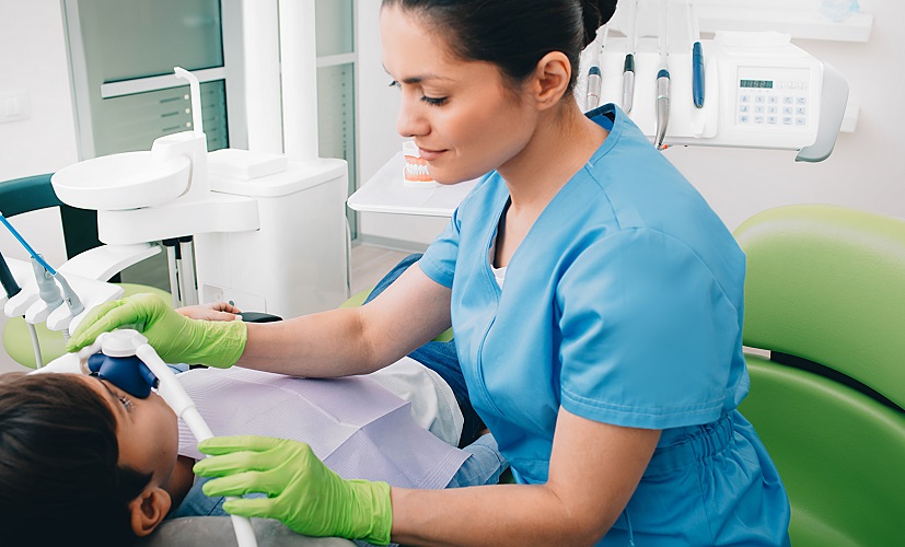 Lekarz dentysta zakłada dziecku maskę do sedacji wziewnej gazem rozweselającym