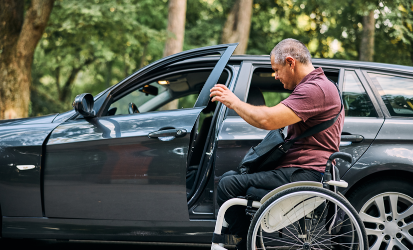 Mężczyzna na wózku wsiada do samochodu - może odliczyć koszty związane z samochodem dzięki uldze rehabilitacyjnej